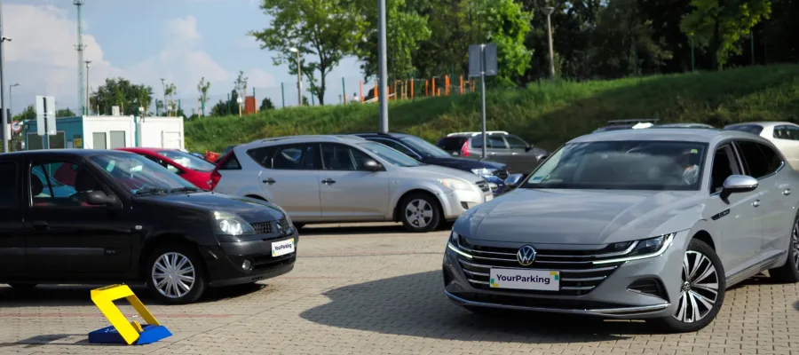 Egy autó akar beparkolni épp egy YourParking okos parkolásgátlóvl védett parkolóhelyre.